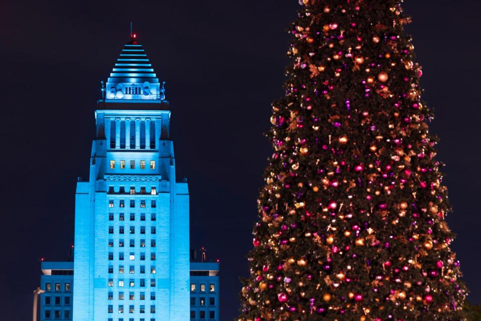 Framed by a Christmas tree, night time view of the 1928 constructed downtown City Hall of Los Angeles, California, USA.