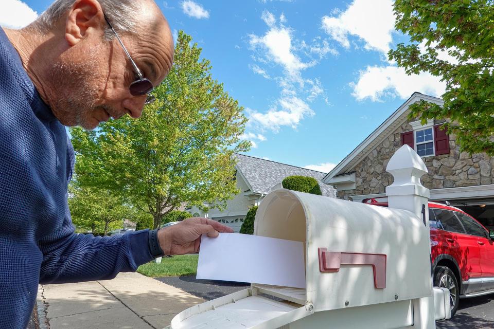Gentleman getting letters from mailbox.